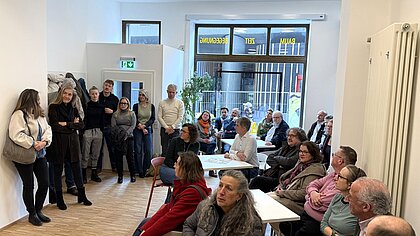Menschen stehen und sitzen bei der Einweihung in den frisch renovierten Räumen der Pauline 