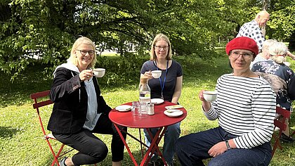 Die evangelische Pfarrerin Dorothee Niethammer-Schwegler, die Sozialpädagigin Anne-Maria Sontheimer von der katholischen Gesamtkirchengemeinde Stuttgart-Neckar und Katja Simon von der Bürgerstiftung Stuttgart an einem der gedeckten Kaffeetische auf dem Hauptfriedhof in Steinhaldenfeld