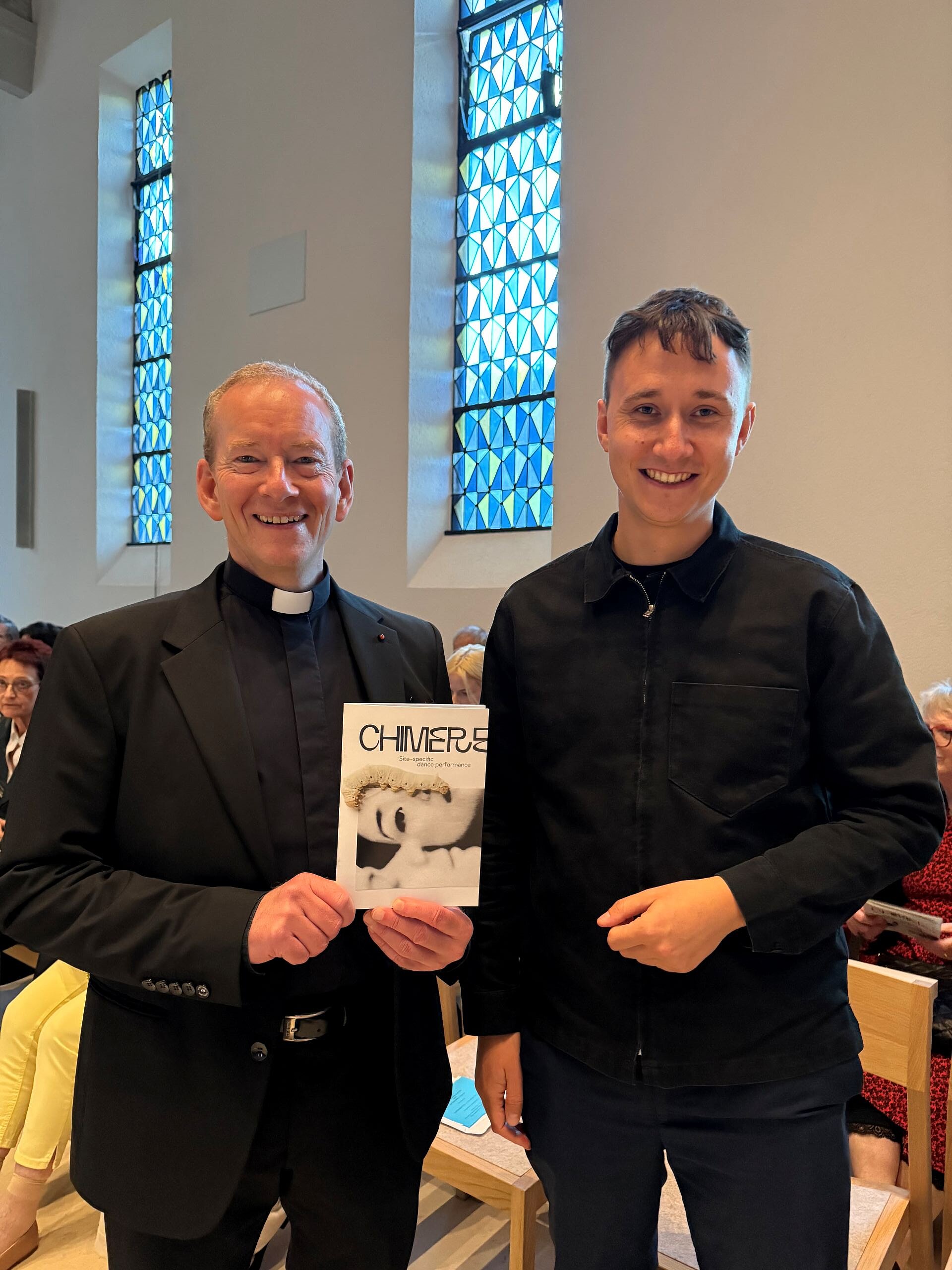 Der katholische Stadtdekan mit einem Programmheft von CHIMERE und neben ihm der Degerlocher Bezirksvorsteher Colyn Heinze