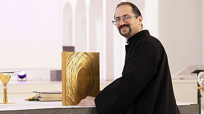 Christian Storch platziert das Evangeliar am Altar von St. Georg.